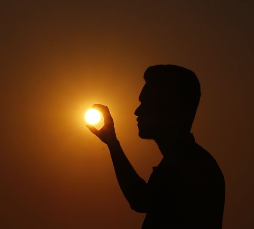 Homme qui prend le soleil entre ses doigts